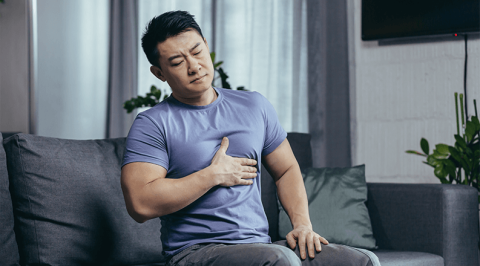 Man sitting with hand on chest