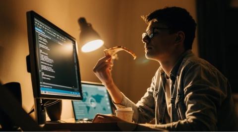 Man eating pizza at night